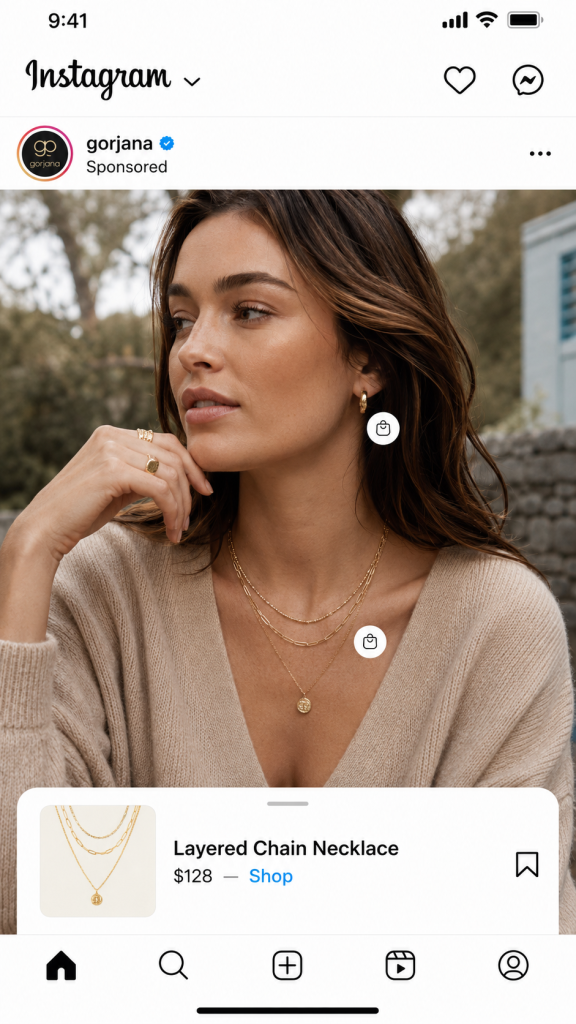 Gorjana sponsored Instagram ad: model in a beige sweater wearing layered gold necklaces, with tap-to-shop tags linking to a $128 Layered Chain Necklace.