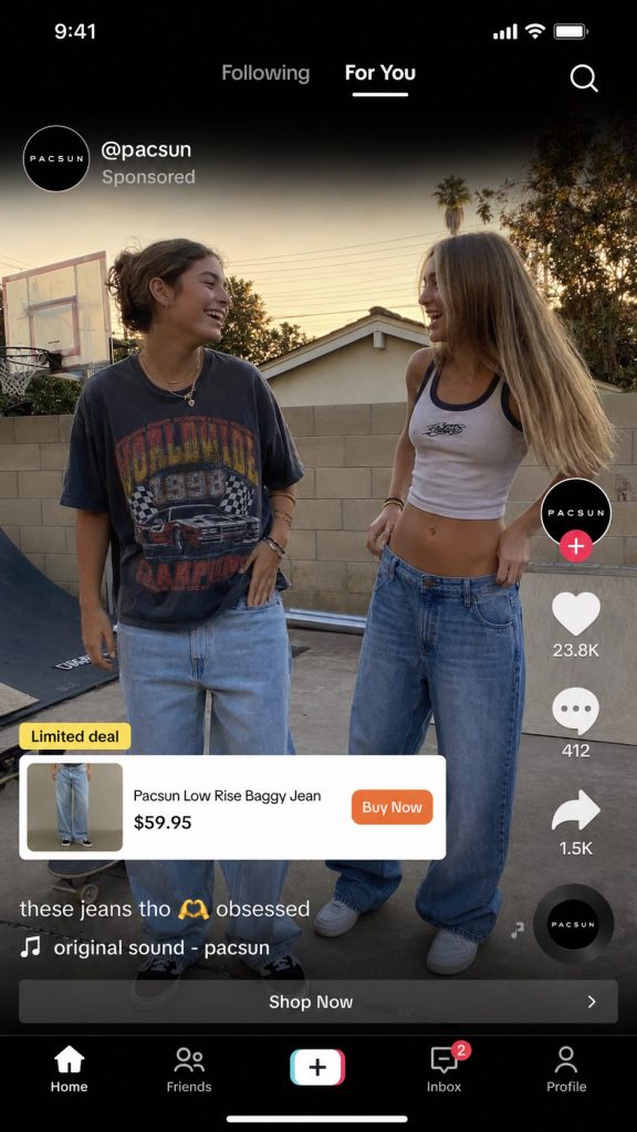 Pacsun TikTok ad mockup showing two Gen Z teens in baggy denim with a TikTok Shop product card overlay displaying "Pacsun Low Rise Baggy Jean $59.95" and an orange Buy Now button.