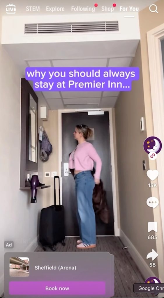Premier Inn TikTok Travel Ad: a traveler with a suitcase entering a hotel room, captioned "why you should always stay at Premier Inn," with a dynamic "Sheffield (Arena) — Book now" hotel card, showing intent-matched booking.