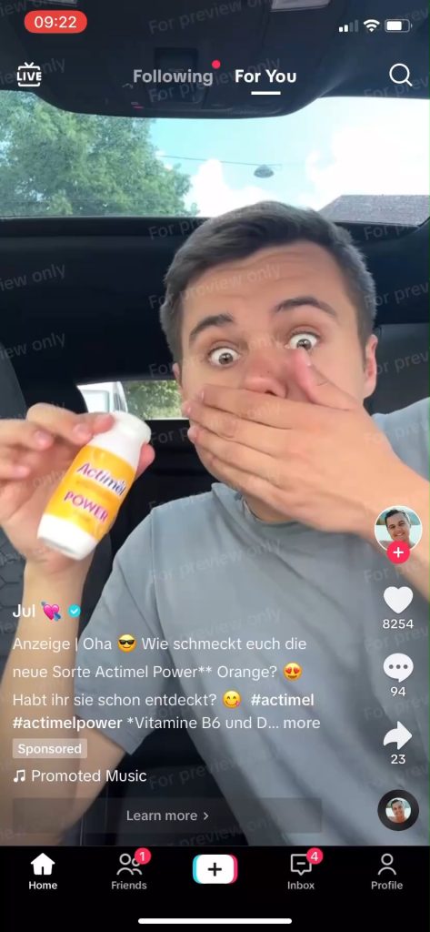 Sponsored TikTok ad from Actimel featuring a creator in a car holding an Actimel POWER drink with a surprised reaction.