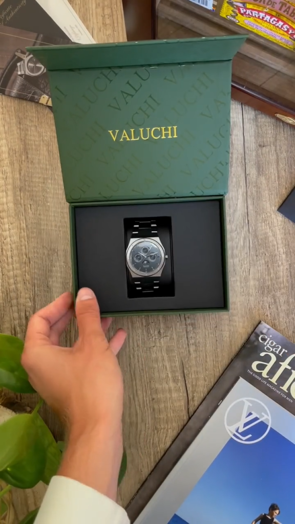UGC-style TikTok unboxing ad from Valuchi featuring a creator opening a green branded watch box to reveal a chronograph timepiece.