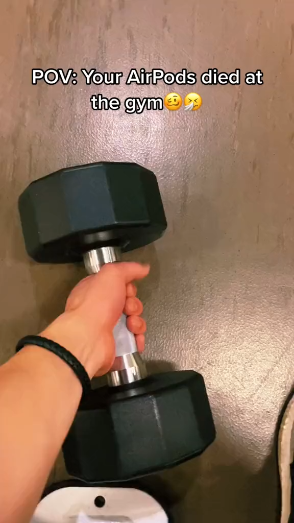 Problem-solution TikTok ad showing a hand holding a dumbbell with a POV style hook about AirPods dying at the gym.