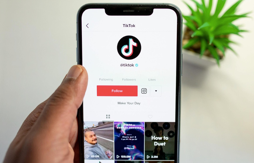 A person holding a phone, showing the TikTok interface.