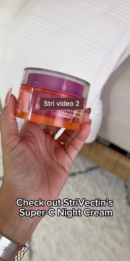 Hand holding StriVectin Super-C Night Cream jar, with text captions overlaid on a bedroom background.