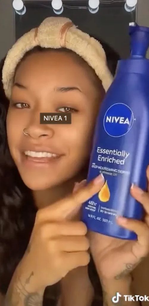 Smiling woman in a headband holds a blue NIVEA Essentially Enriched body lotion bottle. TikTok logo visible.