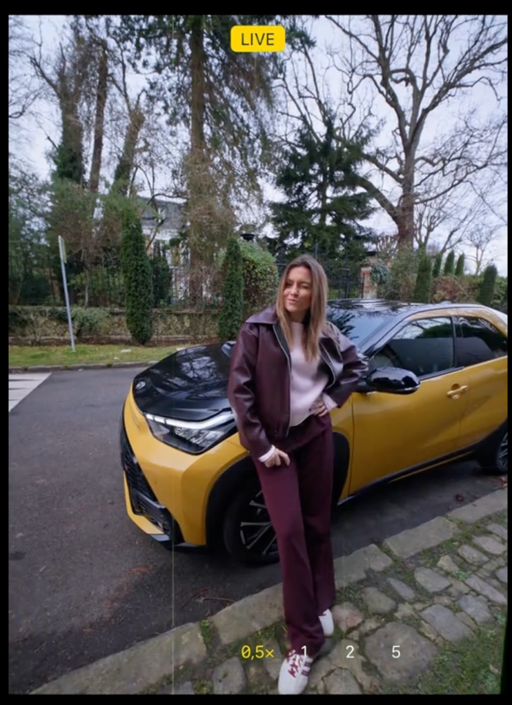 Woman leaning against a Toyota Aygo X GR Sport car