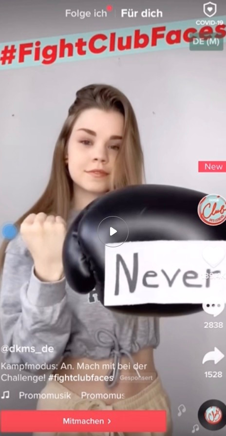Young woman holds boxing glove reading "Never" in a #FightClubFaces TikTok video by @dkms_de.