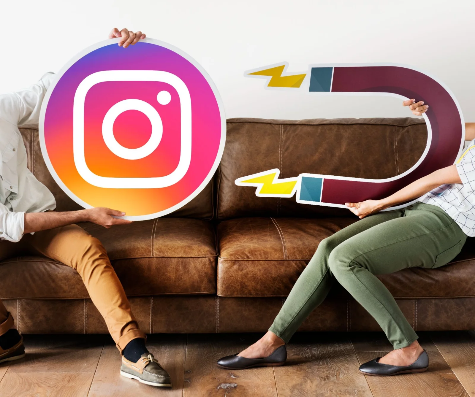 Two people on a couch holding an Instagram logo and magnet props.