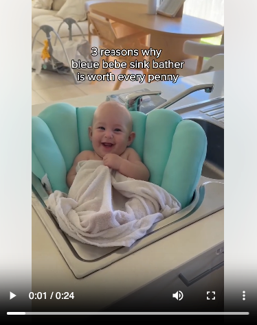 Still from a product-in-use video ad showing a baby using a sink bather.